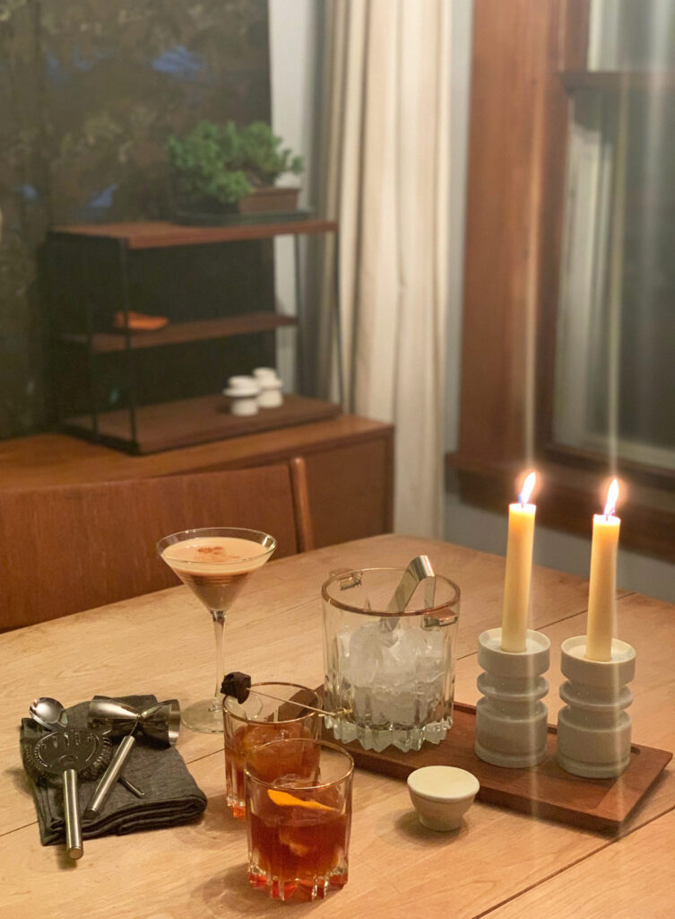 Table with spiced creme de cacao cocktails, an ice bucket, and two taper candles